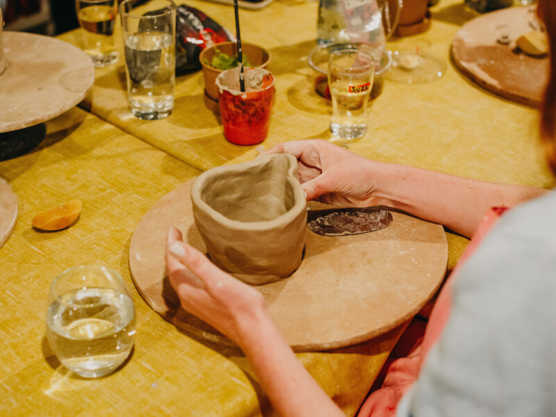 A woman shaping clay at a pottery making class.